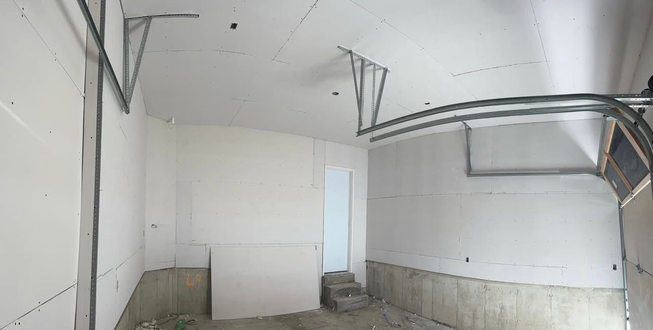 Drywall installation in Mississauga garage with garage door framing